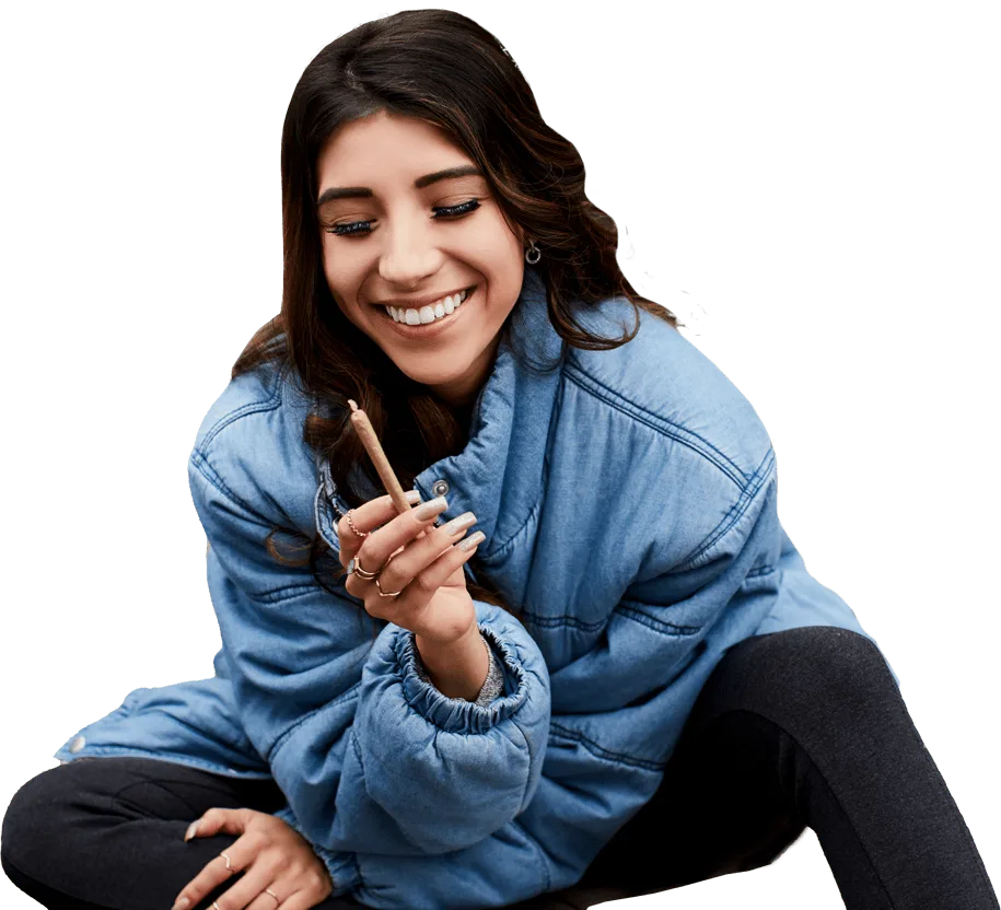 Woman smiling while holding cannabis joint in hand